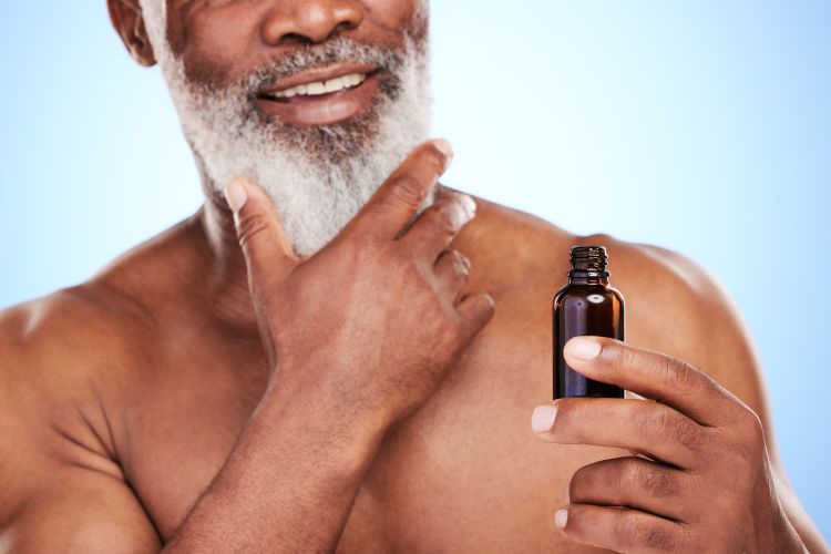 Man applying beard oil to his full beard