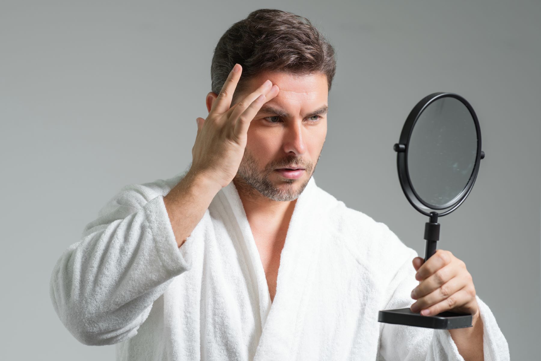 Man checking how big his forehead is