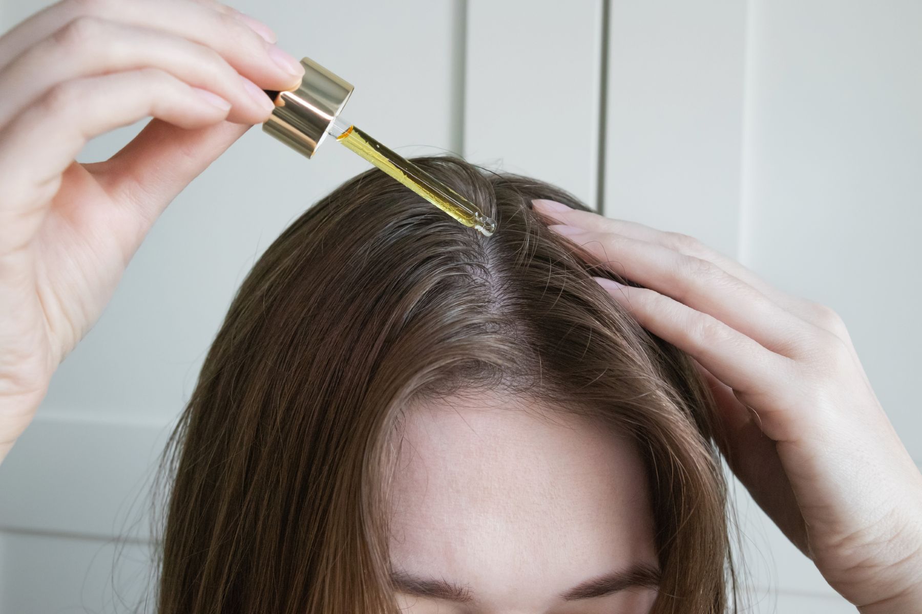 Woman applying almond oil for hair health