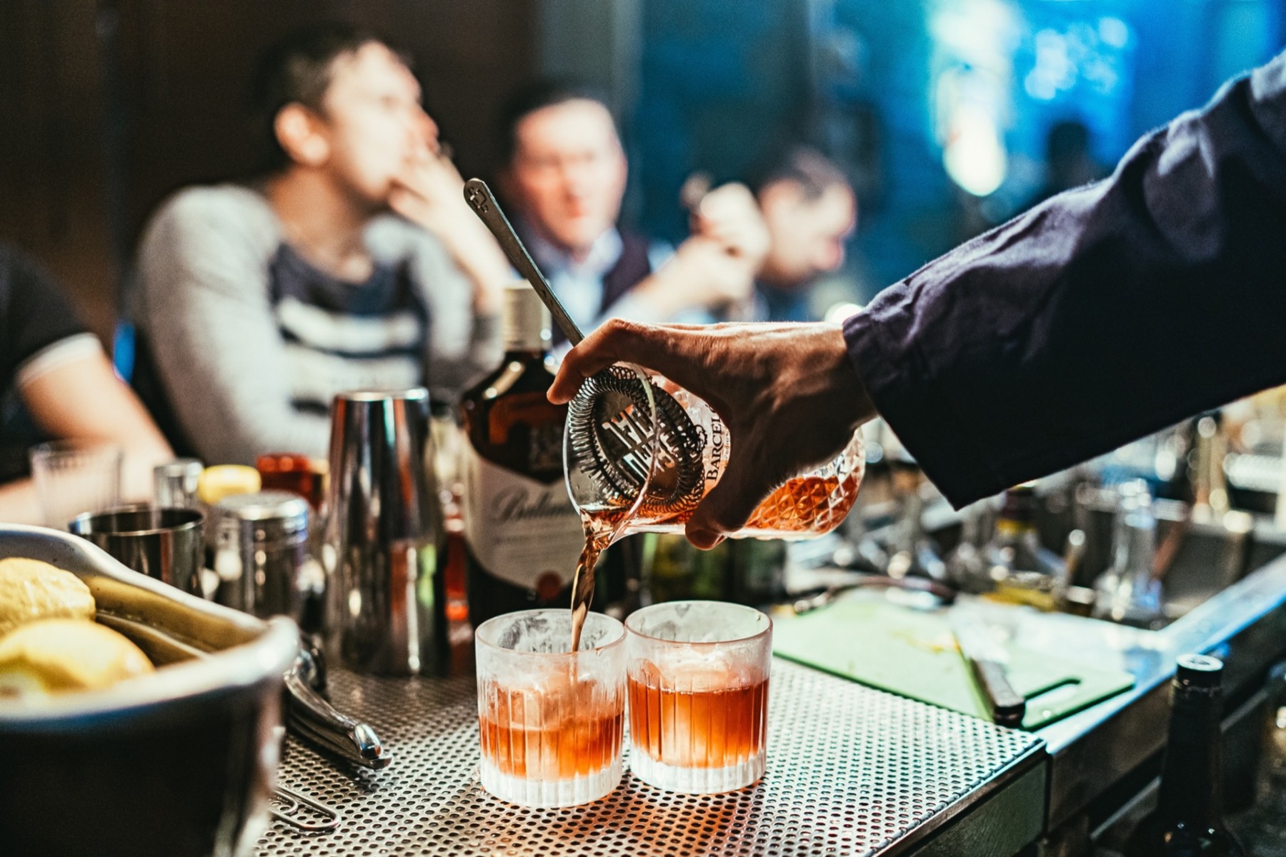 alcoholic drinks being poured at a bar